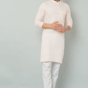 Man wearing a pink kurta and white pants.